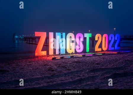 Allemagne, Mecklembourg-Poméranie occidentale, Zingst, lettrage 'Zingst 2022' fait de lettres illuminées, derrière lui la jetée de la station de la mer Baltique Banque D'Images