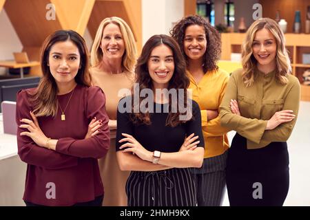Portrait de l'équipe d'affaires féminines multiculturelles debout dans le bureau du plan ouvert moderne Banque D'Images