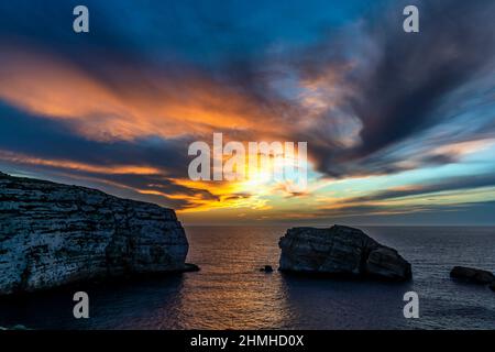 Le soleil se couche dans des couleurs glorieuses sur la baie de Dwejra sur Gozo Banque D'Images