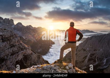 Randonneur admirant les Dolomites au lever du soleil devant Cadini di Meurina, Auronzo di Cadore, Belluno, Vénétie, Italie Banque D'Images