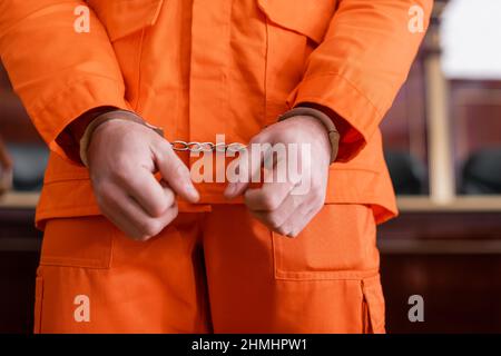 vue courte de l'accusé dans les menottes et uniforme de prison orange dans le tribunal Banque D'Images