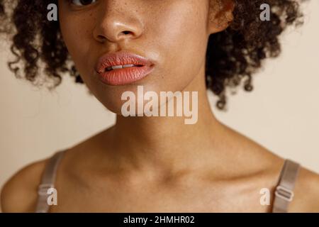 Modèle femelle avec maquillage naturel posé sur fond beige Banque D'Images