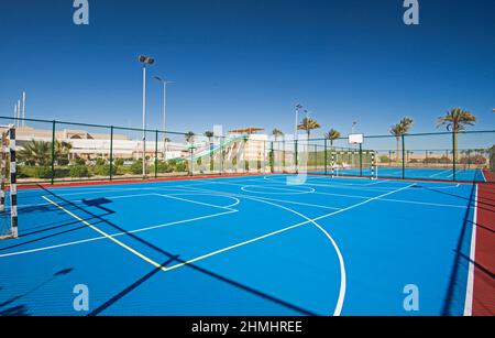 Terrain de sport polyvalent en terre battue extérieur avec surface bleue et filets au centre de villégiature tropical de l'hôtel Banque D'Images