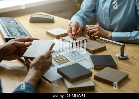 vendeur avec le client qui choisit la conception et les matériaux de la porte en magasin Banque D'Images