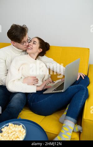 un jeune beau couple shopping en ligne. La fille se achète un cadeau. La femme est heureuse de l'achat Banque D'Images