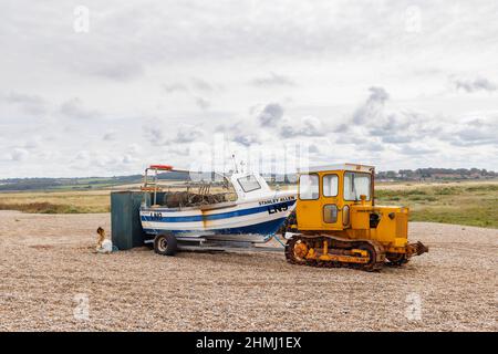 Bateau de pêche sur une remorque tirée par un bouteur à chenilles sur une plage de galets, CLEY-Next-the-Sea, un village côtier de Norfolk, East Anglia, Angleterre Banque D'Images