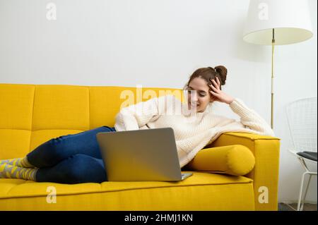 Une jeune femme utilise un ordinateur portable pour travailler à distance ou étudier en ligne Banque D'Images