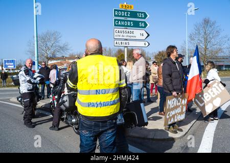 France, Montauban, 2022-02-10. Un homme porte une veste jaune, avec un dessin d'un personnage du Simpsons No Passaran devant le panneau de signalisation indiquant Rodez et Cahors D820. Passage du Convoi de la liberté au rond-point Aussonne à Montauban. Depuis plusieurs jours, des militants anti-pass de santé et anti-vax organisent des convois routiers pour atteindre et bloquer Paris le 11 février. Mouvement de colère né parmi les camionneurs canadiens contre la passe de vaccination. Photo de Patricia Huchot-Boissier/ABACAPRESS.COM France, Montauban, 2022-02-10. Passage du Convoi de la liberté au rond Banque D'Images