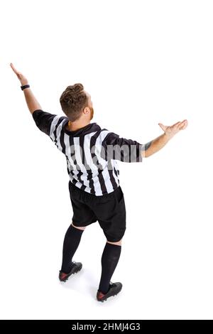 Vue arrière. Portrait complet de l'arbitre de football ou de football portant l'uniforme de juge de terrain isolé sur fond blanc de studio. Concept de sport, règles Banque D'Images