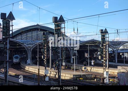 Un train ICE avec ses phares allumés commence à quitter la gare centrale de Cologne. Banque D'Images