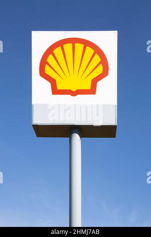 MADRID, ESPAGNE - 6 FÉVRIER 2022 : panneau d'affichage de la station-service et du gaz Shell isolé dans un ciel bleu clair. Banque D'Images