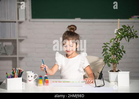 Enfant fille dessin avec coloriage stylos peinture.Portrait d'adorable petite fille souriant joyeusement tout en appréciant l'art et l'artisanat leçon à l'école.Drôle Banque D'Images