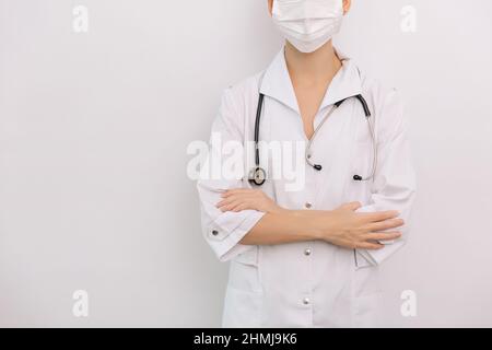 Médecin avec stéthoscope en blouse médicale sur fond blanc.Demi-corps de position avant sans tête.Composition panoramique horizontale.Industrie médicale Banque D'Images