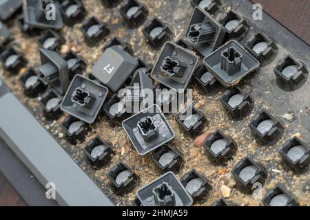 Gros plan d'un clavier d'ordinateur démontable très sale.Démontage d'un clavier d'ordinateur avec vos propres mains, nettoyage du clavier Banque D'Images