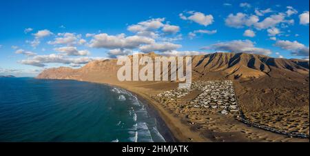 Village de Famara et plage avec les montagnes de Risco de Famara en arrière-plan, Espagne Banque D'Images