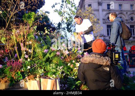 Des plantes et des fleurs couvrent la fontaine commémorative Shaftesbury, souvent connue sous le nom d'« Eros », à Piccadilly Circus, Londres, Angleterre, Royaume-Uni. Cette publicité annonce une expérience de réalité augmentée Green Planet qui ouvrira ses portes à Piccadilly Circus le 11th février 2022. Parmi les partenaires et les partisans de ce projet figurent BBC Earth, EE, Crown Estate, Factory 42, Kew Royal Botanic Gardens, Talesmith et dimension. Le projet propose la réservation de billets gratuits en ligne et dure jusqu'au 9th mars 2022. Un caméraman film Adam, portant un t-shirt blanc, un ambassadeur au projet qui informe les passants sur ce projet. Banque D'Images