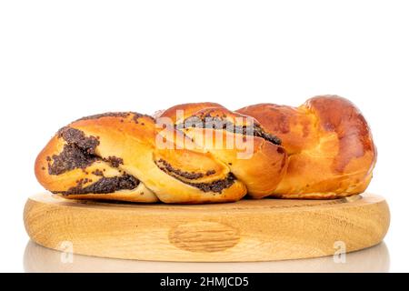 Un savoureux pain de graines de pavot maison sur un plateau en bois, macro, isolé sur un fond blanc. Banque D'Images