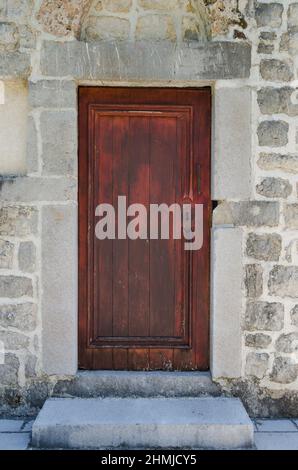 Vieille porte en bois, mur en pierre voûtée.rustique et de style rétro close-up. Banque D'Images