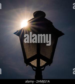 Une lanterne de rue, avec le soleil se levant derrière elle, rétro-éclairage du sujet et de créer une belle étoile de soleil Banque D'Images