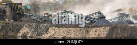 Usine de granit. De grandes piles de pierres de granit près du lac et de la carrière de granit. Banque D'Images
