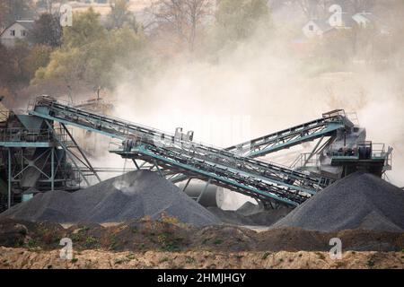 Usine de granit. De grandes piles de pierres de granit près du lac et de la carrière de granit. Banque D'Images