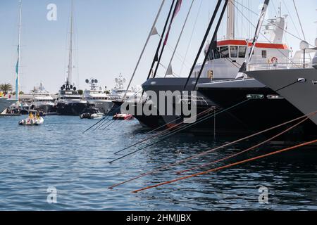 Beaucoup de yachts énormes sont dans le port de Monaco à la journée ensoleillée, Monte Carlo, la montagne est en arrière-plan, de grands mâts de yacht à voile, de bateau à moteur et de méga yachts Banque D'Images