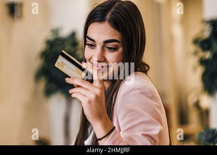 Joyeux souriant jeune femme adulte faisant des achats en ligne, e-shopping entrepreneur satisfait faisant le paiement en ligne payant pour le service ou les marchandises se Banque D'Images