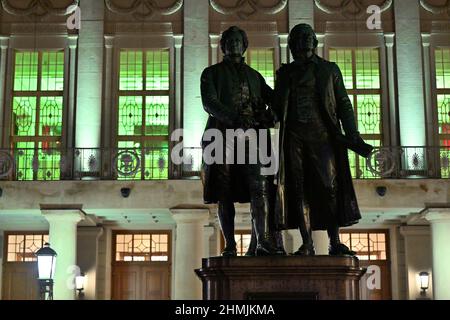 Weimar, Allemagne. 10th févr. 2022. Le foyer néoclassique situé au deuxième étage du Théâtre national allemand de Weimar est éclairé en vert derrière le monument Goethe et Schiller de Theaterplatz. Le 10 février, des campagnes ont été menées dans toute l'Allemagne pour attirer l'attention sur le travail des hospices pour enfants et pour recueillir des fonds. Le Théâtre national allemand de Weimar participe également à la campagne et sera symboliquement éclairé en vert pendant la soirée. Credit: Martin Schutt/dpa-Zentralbild/dpa/Alay Live News Banque D'Images