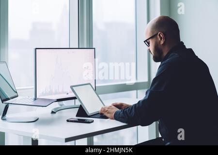 Broker ciblé en tapant sur le clavier de la tablette tout en analysant le graphique Banque D'Images