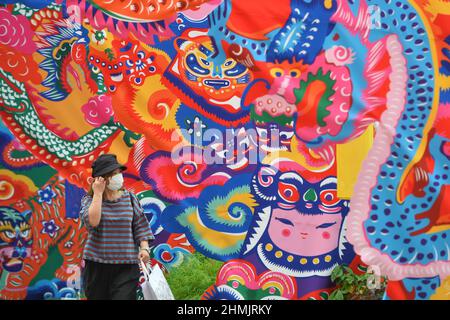 Bangkok, Thaïlande. 10th févr. 2022. Une femme marche devant une installation du Festival de printemps à Bangkok, en Thaïlande, le 10 février 2022. Credit: Rachen Sageamsak/Xinhua/Alay Live News Banque D'Images