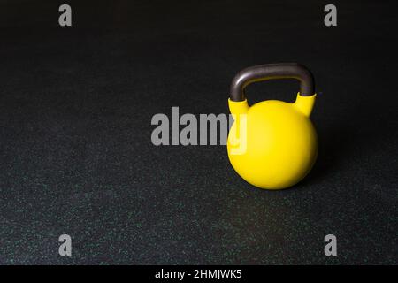 Jaune kettlebell Gym forte puissance, copie spase pour fer lourd pour l'entraînement et le sport arrière-plan, entraîneur noir. Carrossier-constructeur en acier, objet Banque D'Images