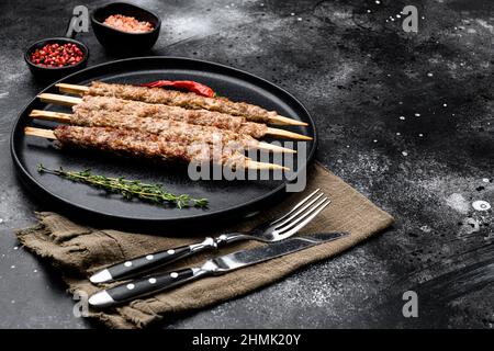 Ensemble de kebab de viande turque, sur plaque, sur fond noir de table en pierre foncée, avec espace de copie pour le texte Banque D'Images