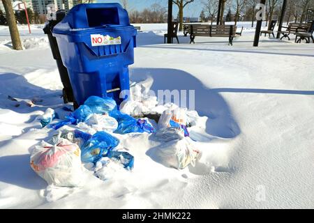 Toronto, Ontario / Canada - 02-06-2022: Les poubelles débordent de déchets et sont jetées sur le sol. Déchets de sacs en plastique déchets dans le parc public. Polluti Banque D'Images