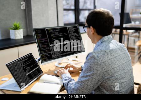 Programmeur d'ordinateur écrivant le code de programme sur l'ordinateur au bureau Banque D'Images