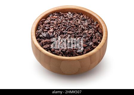 Nibs de cacao biologique crus dans un bol en bois isolé sur fond blanc. Banque D'Images