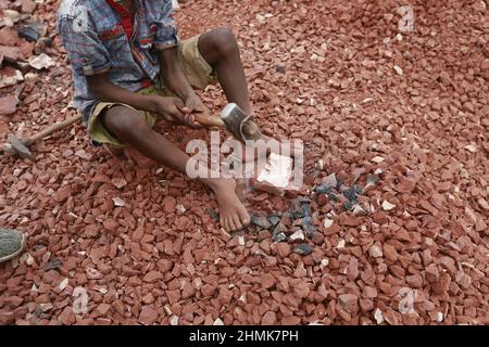 Ramjan, 8 ans, enfants bangladais, brise des briques devant servir de gravier dans la construction à Dhaka, au Bangladesh, le 10 février 2022. Le travail des enfants au Bangladesh est courant, avec 4,7 millions d'enfants âgés de 5 à 14 ans sur le marché du travail. Parmi les enfants travailleurs qui travaillent dans la population active, 83 % sont employés dans les zones rurales et 17 % dans les zones urbaines. En 2006, le Bangladesh a adopté une loi sur le travail fixant à 14 ans l'âge légal minimum pour l'emploi. Néanmoins, l'application de telles lois du travail est pratiquement impossible au Bangladesh parce que 93% des enfants travailleurs sont employés dans le secteur informel tel que Smal Banque D'Images