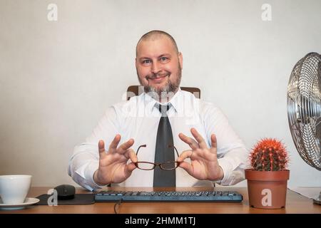 L'homme décrit comiquement le travail d'un homme d'affaires. Il montre le contentement et la joie sur son visage et sa posture. Banque D'Images