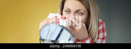 Jeune femme regarde dans le miroir et les saignements de nez Banque D'Images