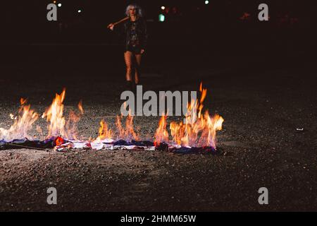 Portrait de la jeune femme blonde élégante grunge avec le club près du feu Banque D'Images