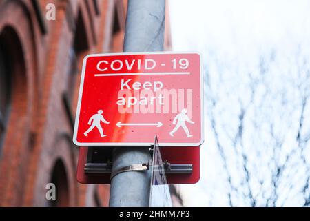 La signalisation de rue pour essayer de contrôler la propagation de COVID-19 rappelle aux gens la distance sociale due à la pandémie. Banque D'Images