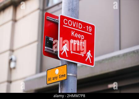 La signalisation de rue pour essayer de contrôler la propagation de COVID-19 rappelle aux gens la distance sociale due à la pandémie. Banque D'Images