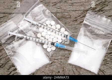 Seringue d'injection de drogue et héroïne cuite dans un sac sur une table en bois grundy Banque D'Images