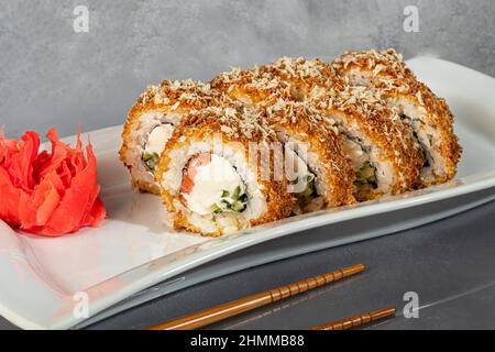 Les sushis Uramaki, Californie, Philadelphie, roulent sur une assiette blanche. Menu pour les restaurants, cafés. Sur un arrière-plan réfléchissant foncé. Espace de copie Banque D'Images
