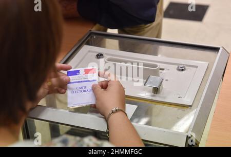 Bureau de vote à Evreux (nord de la France) le 2017/06/11: Personne tenant une carte d'inscription devant une boîte de scrutin à l'occasion du premier tour des élections législatives de 2017 Banque D'Images