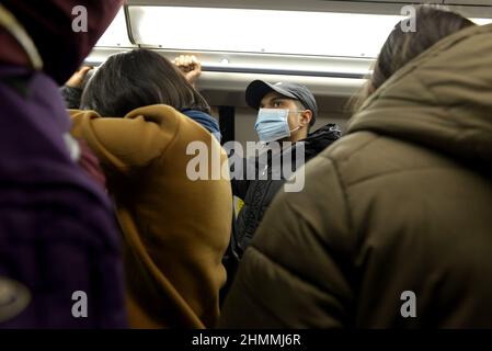 Londres, Angleterre, Royaume-Uni. Métro de Londres: Homme portant un masque COVID sur un train de métro bondé. Janvier 2022 Banque D'Images