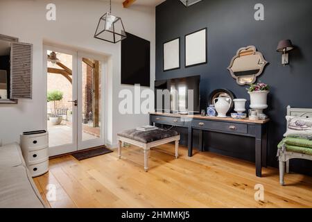 Newport, Essex - juillet 10 2018 : couloir avec murs gris foncé et blancs contrastés, parquet en bois exposé, plafond haut et ordinateur Banque D'Images