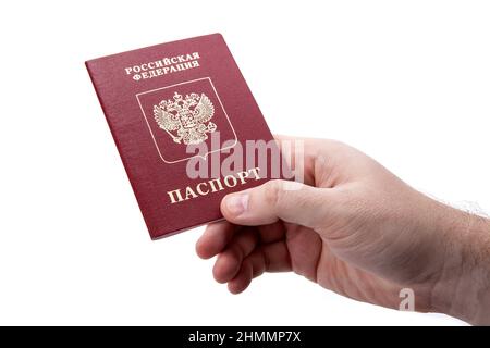 Passeport russe dans la main d'un homme sur fond blanc comme identification isolée Banque D'Images