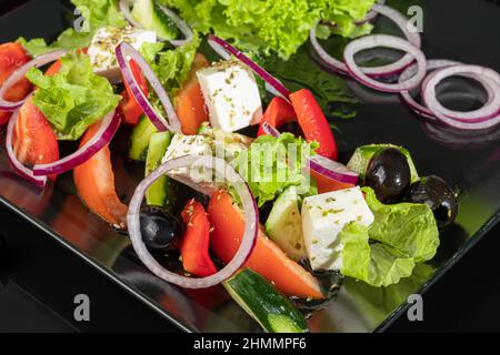 Salade grecque avec feta, tomates, olives et laitue. Sur un arrière-plan sombre. Espace de copie Banque D'Images