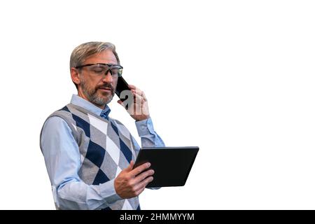 Taille haute Portrait d'homme d'affaires confiant, beau, aux cheveux gris. Homme debout et utilisant un smartphone et une tablette numérique . Banque D'Images