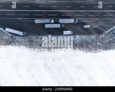 Chariots stationnés près de la route dans le parking. Paysage d'hiver vue de dessus. Copier l'espace sur de la neige blanche Banque D'Images